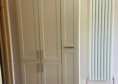 KAP Woodwork & Building Services | Kitchen & Bathroom Fitting Tall cream Shaker larder pantry unit beside a vertical radiator fitted in Dorset