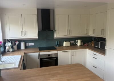 KAP Woodwork & Building Services | Kitchen & Bathroom Fitting Full view of cream L-shaped Shaker kitchen with black extractor and oak worktops fitted in Dorset