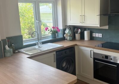KAP Woodwork & Building Services | Kitchen & Bathroom Fitting Cream Shaker kitchen with sink under window, integrated oven and induction hob fitted in Dorset