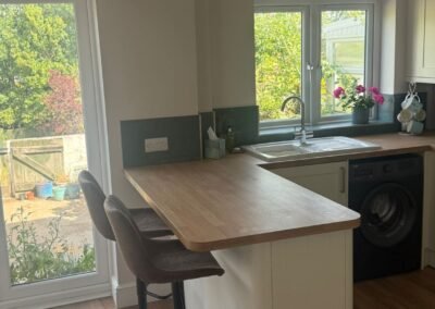 KAP Woodwork & Building Services | Kitchen & Bathroom Fitting Cream kitchen breakfast bar with bar stools and garden views fitted in Dorset