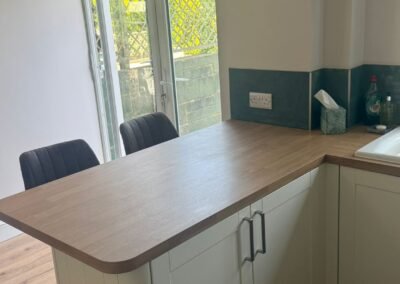KAP Woodwork & Building Services | Kitchen & Bathroom Fitting Cream Shaker kitchen with oak-effect worktop and breakfast bar peninsula fitted by KAP in Dorset