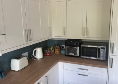 KAP Woodwork & Building Services | Kitchen & Bathroom Fitting Corner of cream Shaker kitchen with oak-effect worktop and wall units fitted in Dorset